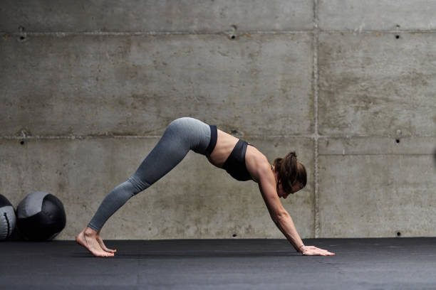istock Fit woman in a modern gym working flexibility and strength through various exercises, demonstrating her commitment to fitness 1492631735