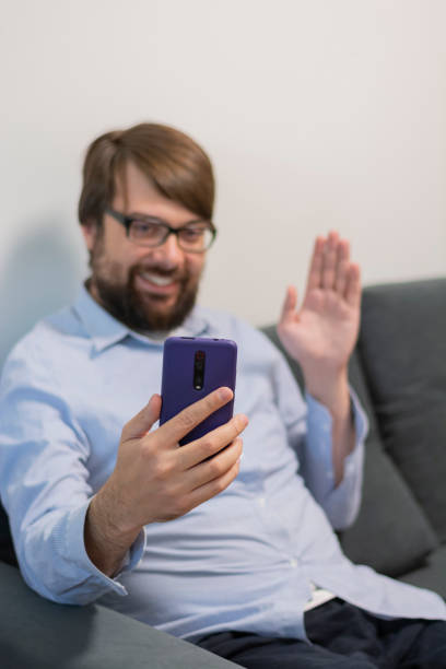 istock Smiling man with white teeth talking on the phone waving his hand using the phone 1492636490