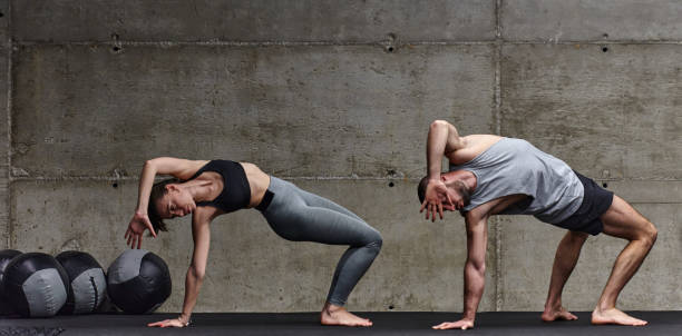 An attractive couple in the gym engaging in various stretching exercises together, showcasing their dedication to fitness, flexibility, and overall wellbeing. With synchronized movements, they demonstrate coordination, balance, and endurance while supporting and motivating each other on their fitness journey. una pareja atractiva en el gimnasio participando en varios ejercicios de estiramiento juntos, mostrando su dedicación al fitness, la flexibilidad y el bienestar general. con movimientos sincronizados, demuestran coordinación, equilibrio y resistencia mie