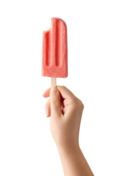 Woman hand holding bitten pink fruit popsicle on white background Woman hand holding bitten pink fruit popsicle isolated on white background. Strawberry and watermelon flavor popsicle stick stock pictures, royalty-free photos & images