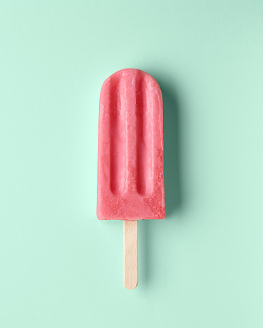 Pink fruit and berry popsicle on pastel mint background. Watermelon and strawberry flavor