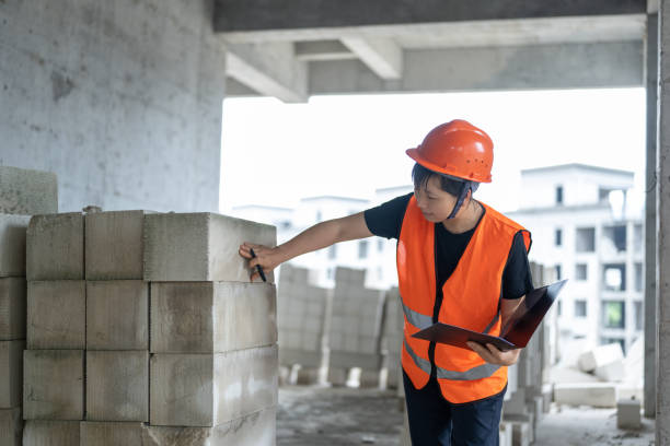 una trabajadora de la construcción trabaja en un proyecto de construcción en curso - blueprint construction worker real estate new fotografías e imágenes de stock