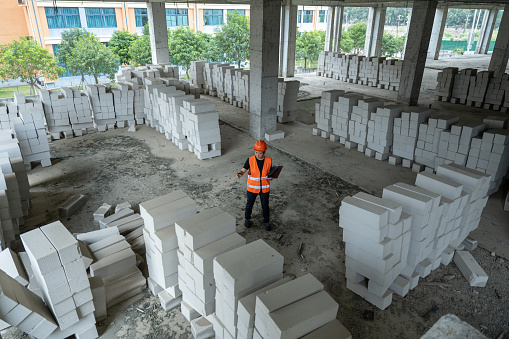 A female construction engineer works on an unfinished construction site