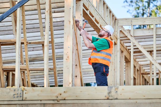 istock Carpenter hammering nail while constructing wooden frame two-story house. 1492639444