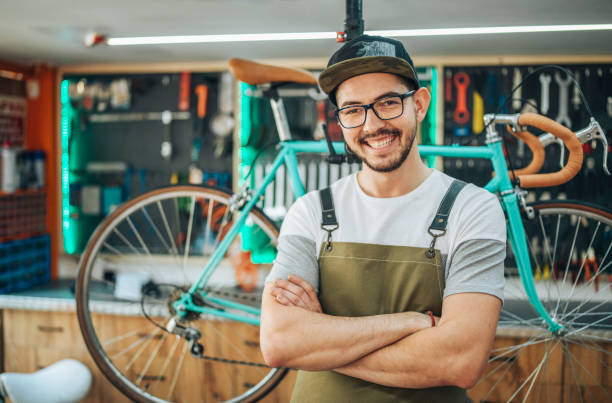 Portrait of a bike shop owner. Portrait of a small business bike shop owner smiling and looking at the camera. bike workshop stock pictures, royalty-free photos & images