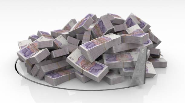 британские банкноты падают через отверстие, вырезанное на полу пилой - heap currency british pounds stack стоковые фото и изображения