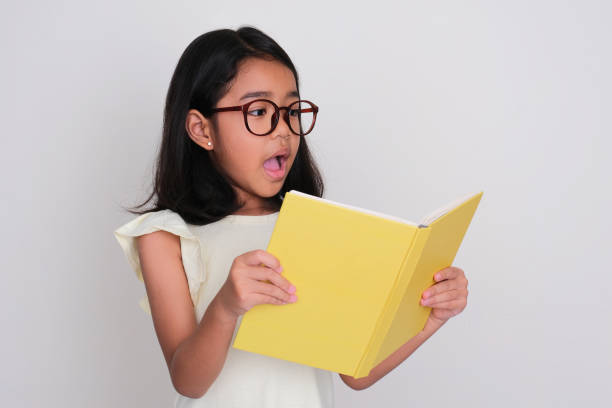istock Asian little girl showing surprised expression when reading a book 1492642397