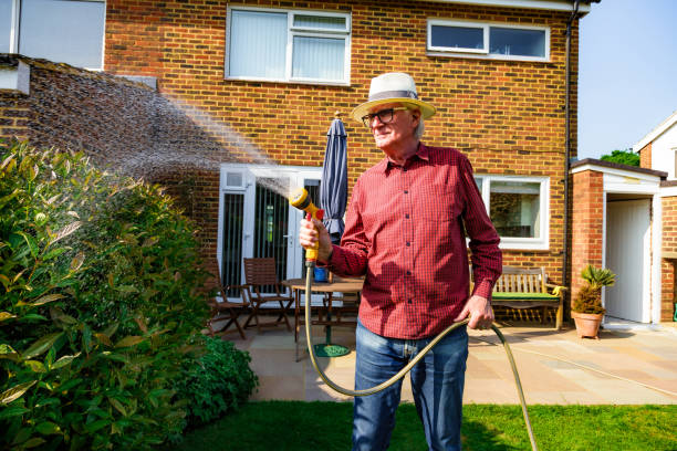 istock Man watering his garden with a hose in summer 1492642856