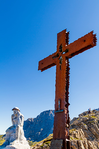 An iron cross and the Thinking Christ welcome the hikers on the Trekking of the Thinking Christ, an easy footpath in the Natural Park Paneveggio-Pale di San Martino. The work is by the sculptor Paolo Lauton, dated 2009.