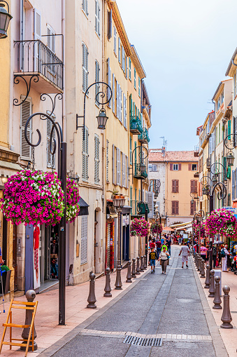 Tourists strolling in the picturesque Rue Georges Clemenceau in the old town of Antibes, a coastal city in the French Riviera