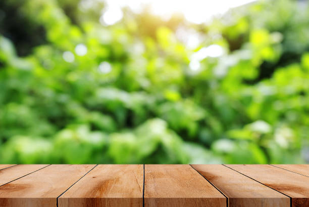 istock Empty wooden table on bright green abstract blurred bokeh background. 1492643287