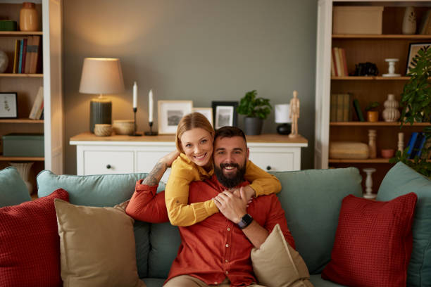 istock Smiling couple hugging on sofa in living room 1492643324