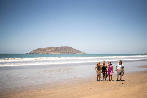 Senior friends talking while walking by the ocean
