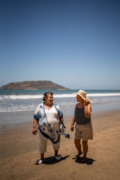 istock Senior friends talking while walking by the ocean 1492644737
