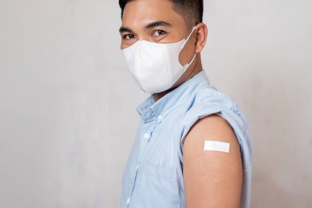 istock Man wearing a mask with arm in plaster after anti-virus injection 1492644817