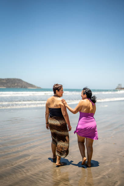 istock Senior friends talking while walking by the ocean 1492644897