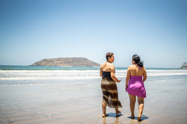 Senior friends talking while walking by the ocean