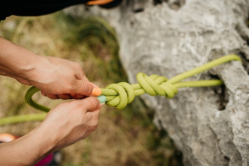Rock climbing, mountain and people with rope and harness for adventure, freedom and extreme sports. Fitness, nature and man and woman attach equipment or gear for training, activity and challenge