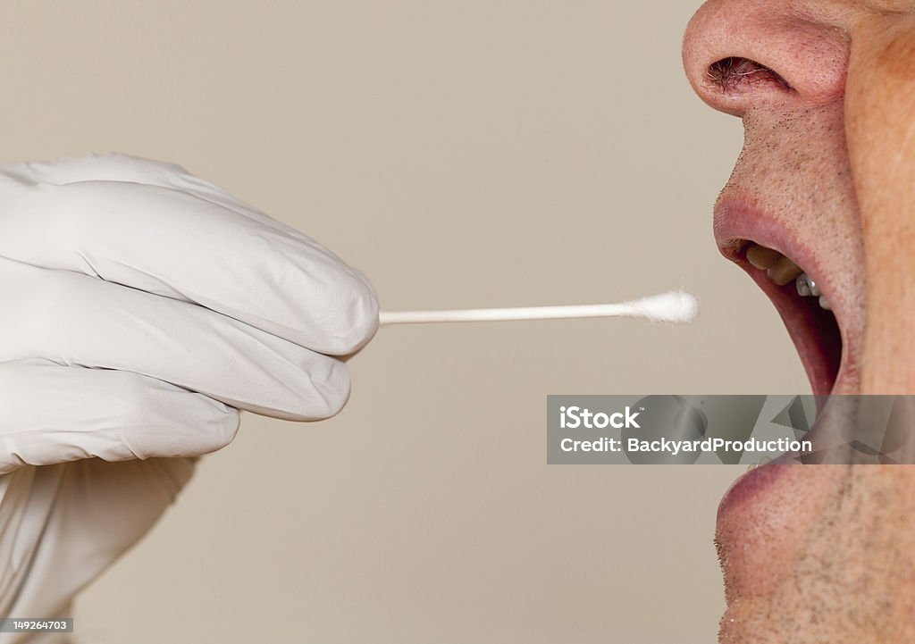 Side view of a mouth open for a DNA swab Gloved hand taking a bodily fluid sample for DNA test from senior male person Medical Test Stock Photo
