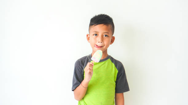 istock handsome boy expression drinking delicious ice cream on white background. Kids model advertisment 1492649757