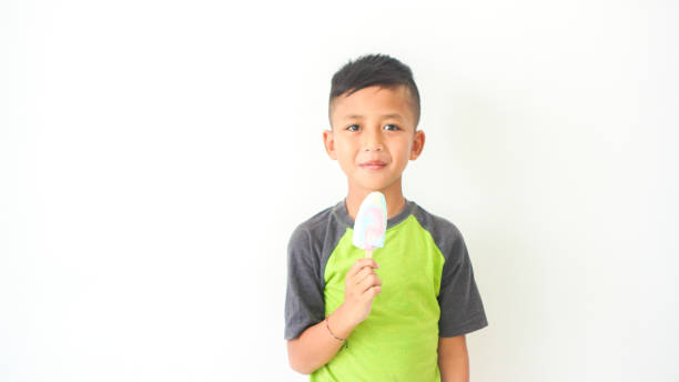 istock handsome boy expression drinking delicious ice cream on white background. Kids model advertisment 1492649760