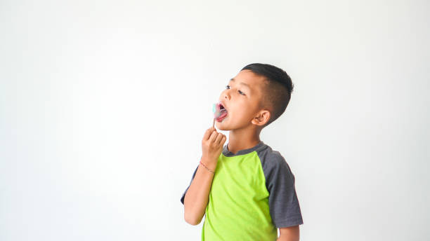 istock handsome boy expression drinking delicious ice cream on white background. Kids model advertisment 1492650089