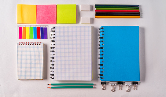 Mockup. An empty school notebook,pencil, erasers,stickers on a white background, top view,flat lay