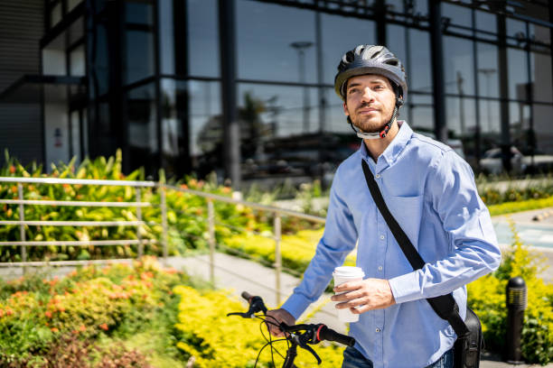 istock Young man walking with bicycle looking around outdoors 1492651694
