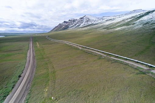 Aerial Drone image of the snow covered mountain peaks and the Alaska Oil Pipeline as it travels north and south along the Dalton Highway near Nuiqsut Alaska
