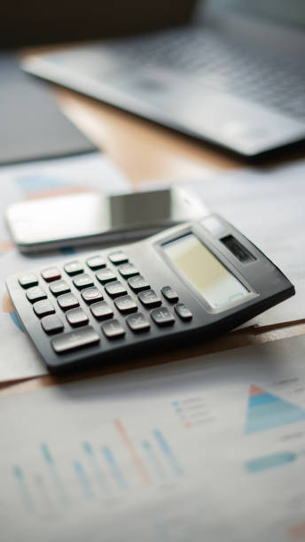 istock Calculator and phone hovering over financial reports concept photo 1492652122