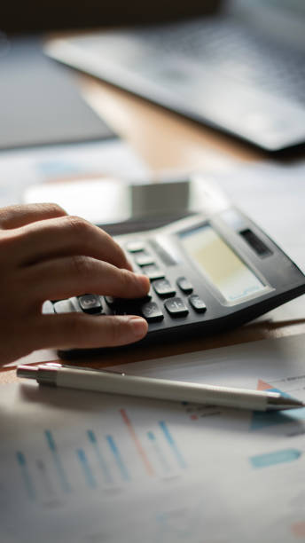 istock Close-up Businessman using calculator while working with financial reports at office 1492652661