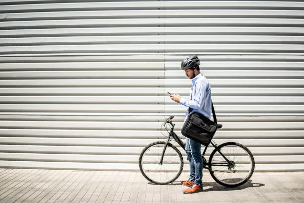 istock Young man using mobile phone with bicycle outdoors 1492653478