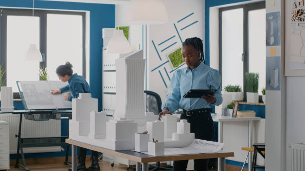 istock Architect using digital tablet to design layout of building model and maquette in office 1492654440