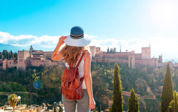 Mujer turista mirando la antigua fortaleza árabe Alhambra- Granada en España - foto de stock