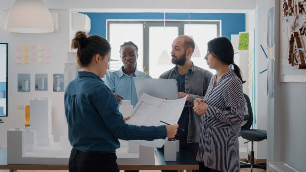 istock Multi ethnic group of architects working with blueprints and building model on table 1492654517