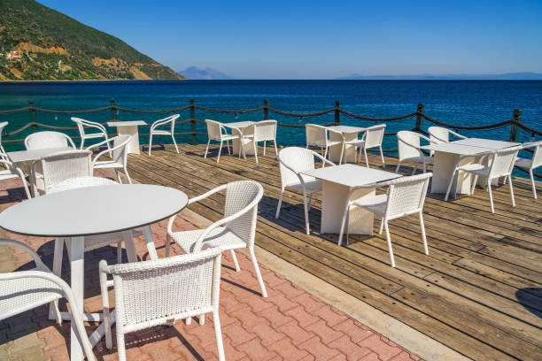 istock Empty cafe with chairs and tables by the seafront under a blue sky in summer. 1492654587