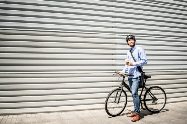 istock Young man walking with bicycle looking around outdoors 1492656590