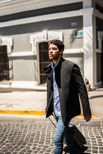 istock Young man walking with luggage outdoors 1492656700