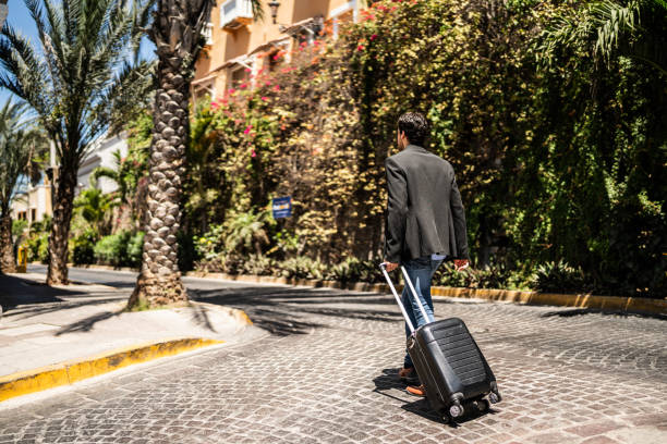 istock Young man walking with luggage outdoors 1492656747