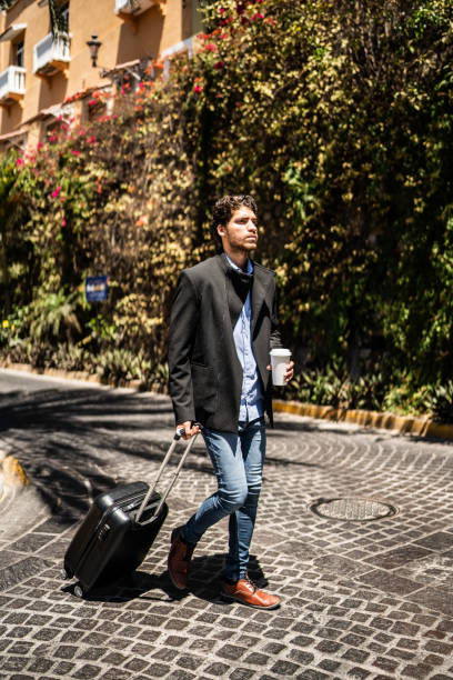istock Young man walking with luggage outdoors 1492656916