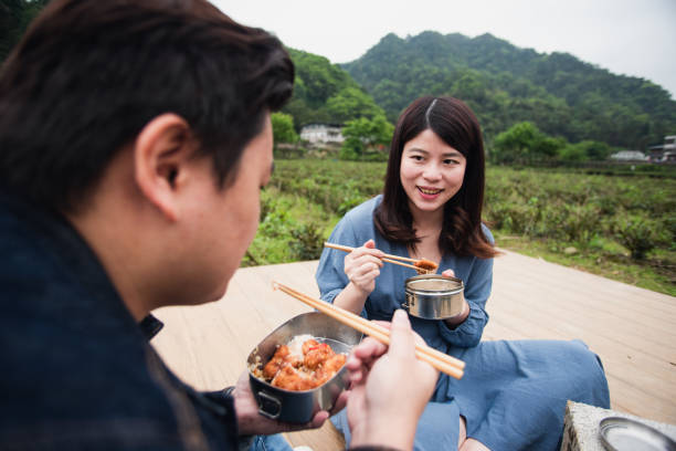 istock Young partner having lunch next to tea field with metal bento box 1492658821