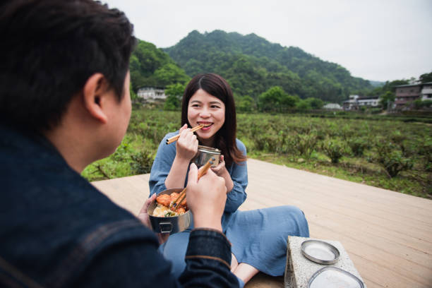 istock Young partner having lunch next to tea field with metal bento box 1492659469