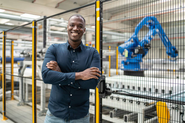 istock Factory manager smiling at the camera in front of production line 1492659567