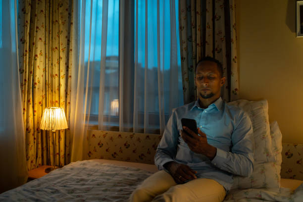 istock Young man readinghis smart phone on his  bed at night 1492659591