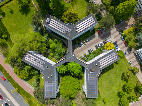 This drone photo is taken from above and shows an apartment building with solar panels on the roof in Leiden.