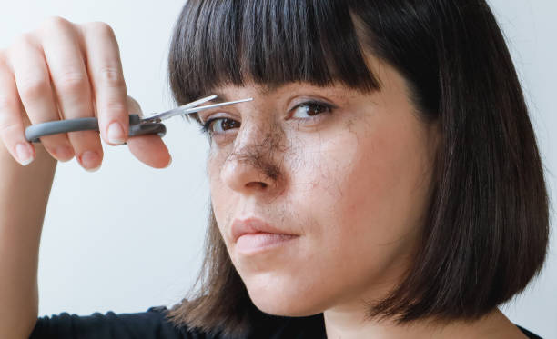 istock The girl cuts her bangs with scissors 1492660516