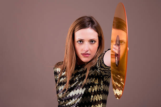 beautiful blonde woman standing holding a golden vinyl disc stock photo