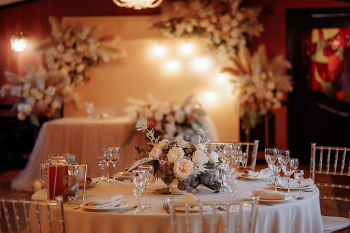 Decoration of the wedding table, evening atmosphere. Preparing for dinner. Garlands over the table. High quality photo