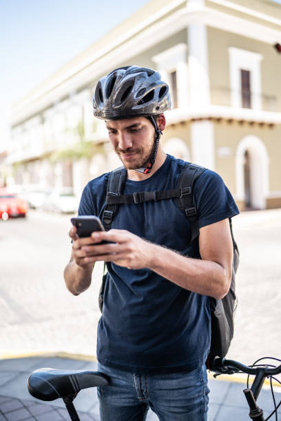 istock Young bike delivery man using mobile phone outdoors 1492662239