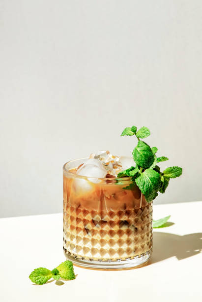 mint white russian alcoholic cocktail drink with vodka, coffee liqueur, mint schnapps, cream and ice on beige background, hard light, shadow pattern, copy space - hard liqueur imagens e fotografias de stock